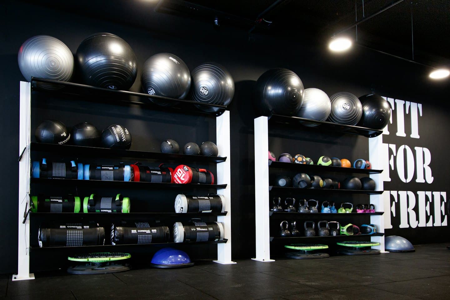 Gym with black shelves holding diverse fitness equipment.
